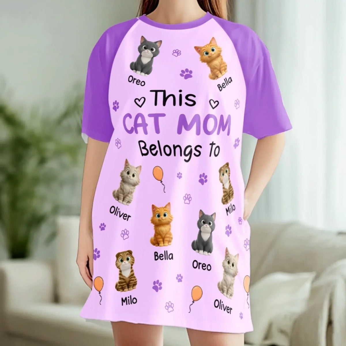 Woman at home wearing the lilac Cat Mom nightgown with her cats' names printed around her