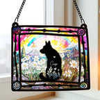 Dog memorial suncatcher hanging in a window with the dog name Coop on the silhouette