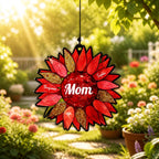 Personalized red sunflower suncatcher with Mom at the center and three family names, hanging in a blooming garden